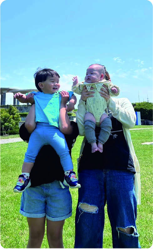 写真：ご主人と一緒にお子さんを抱き上げるMさん